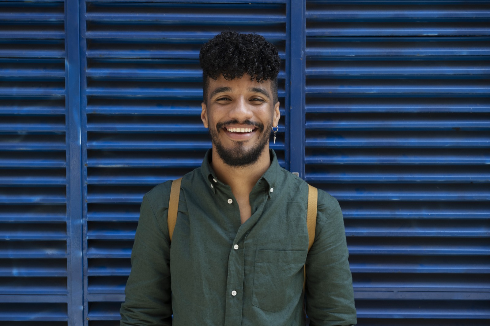 Man smiling against a blue wall