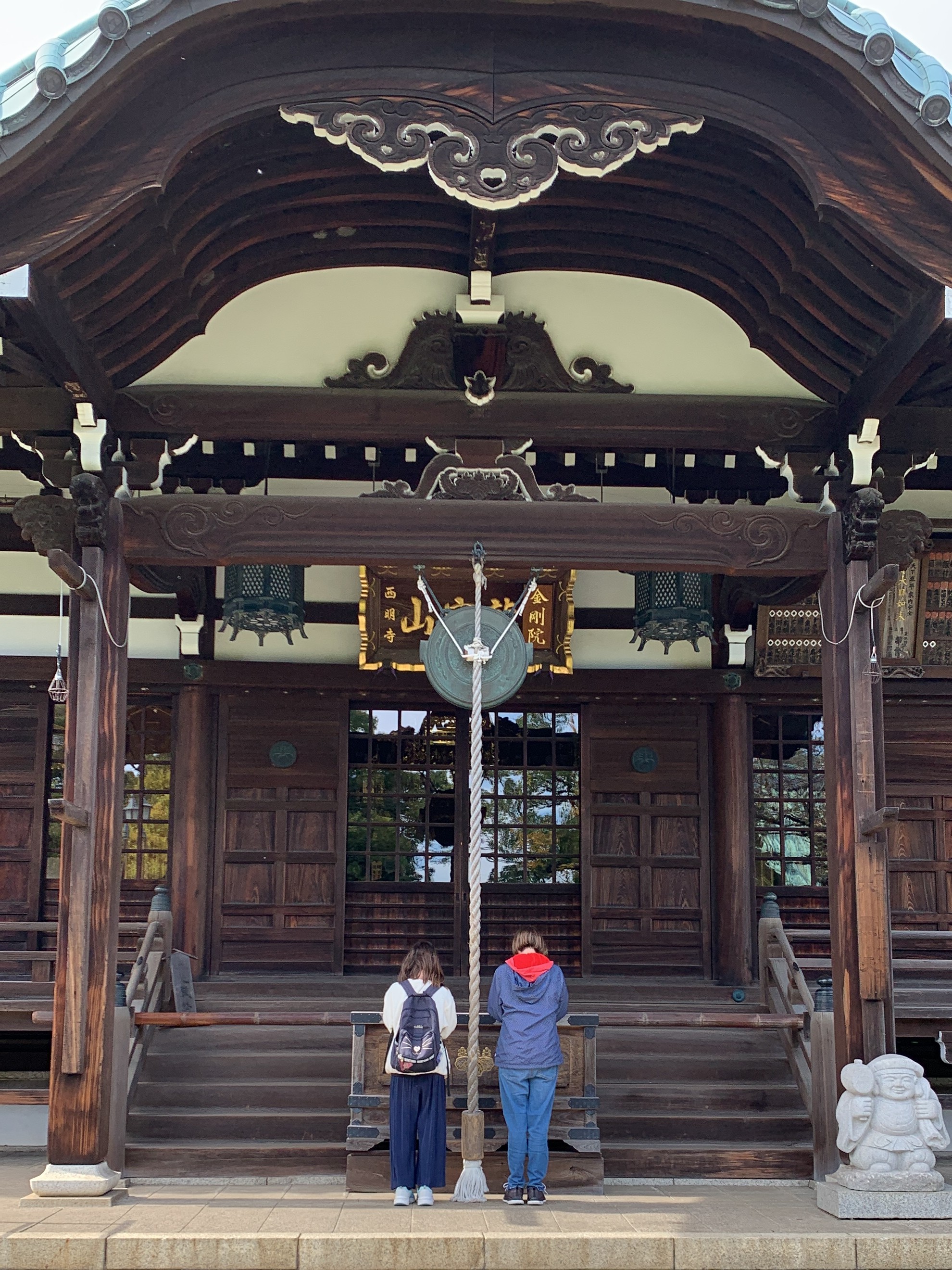 Cory and her daughter bowing at a traditional shrine in Japan.