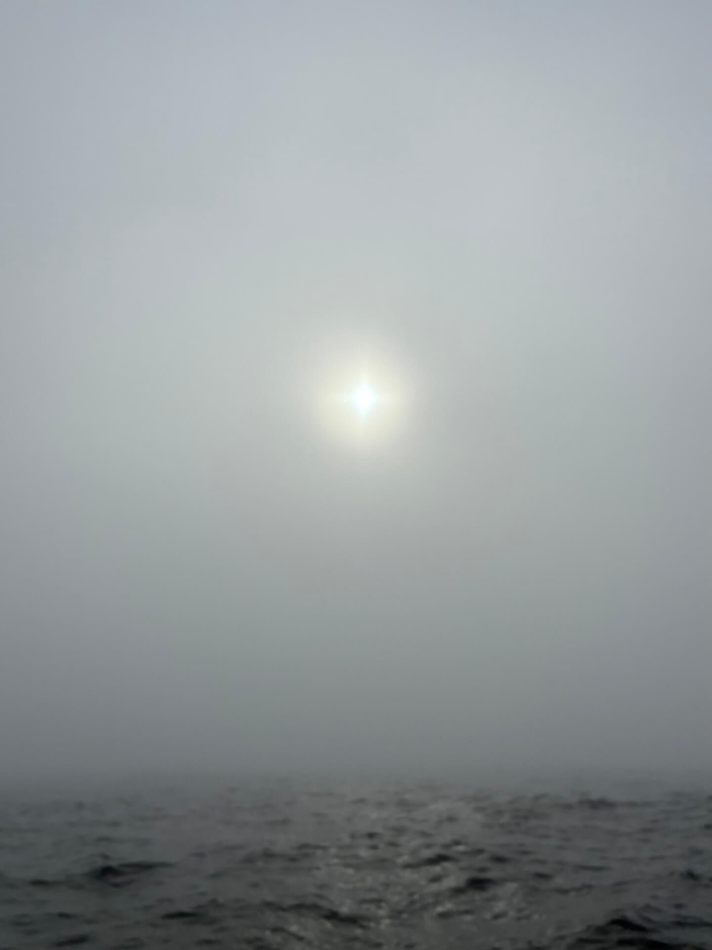 Dichte mist op zee met de zon nauwelijks zichtbaar, een situatie waarbij radar en AIS onmisbaar zijn.