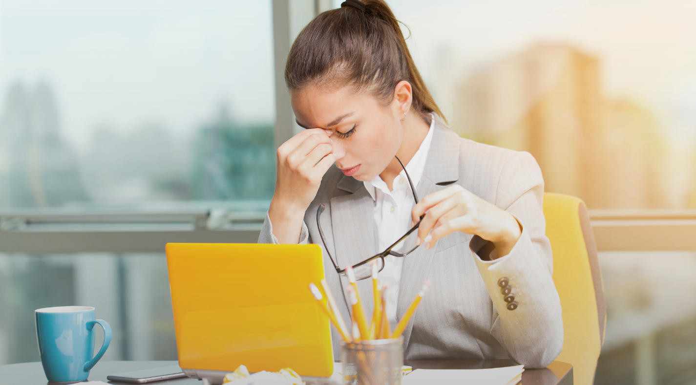 Professional woman feeling overwhelmed at her desk