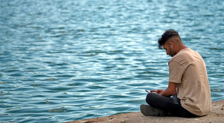 A person in nature enjoying a NeuraSonic program at the beachside.