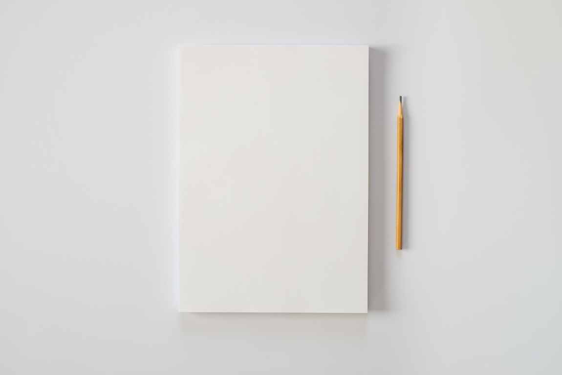 A stack of blank sheets of paper and a pencil on a white background.