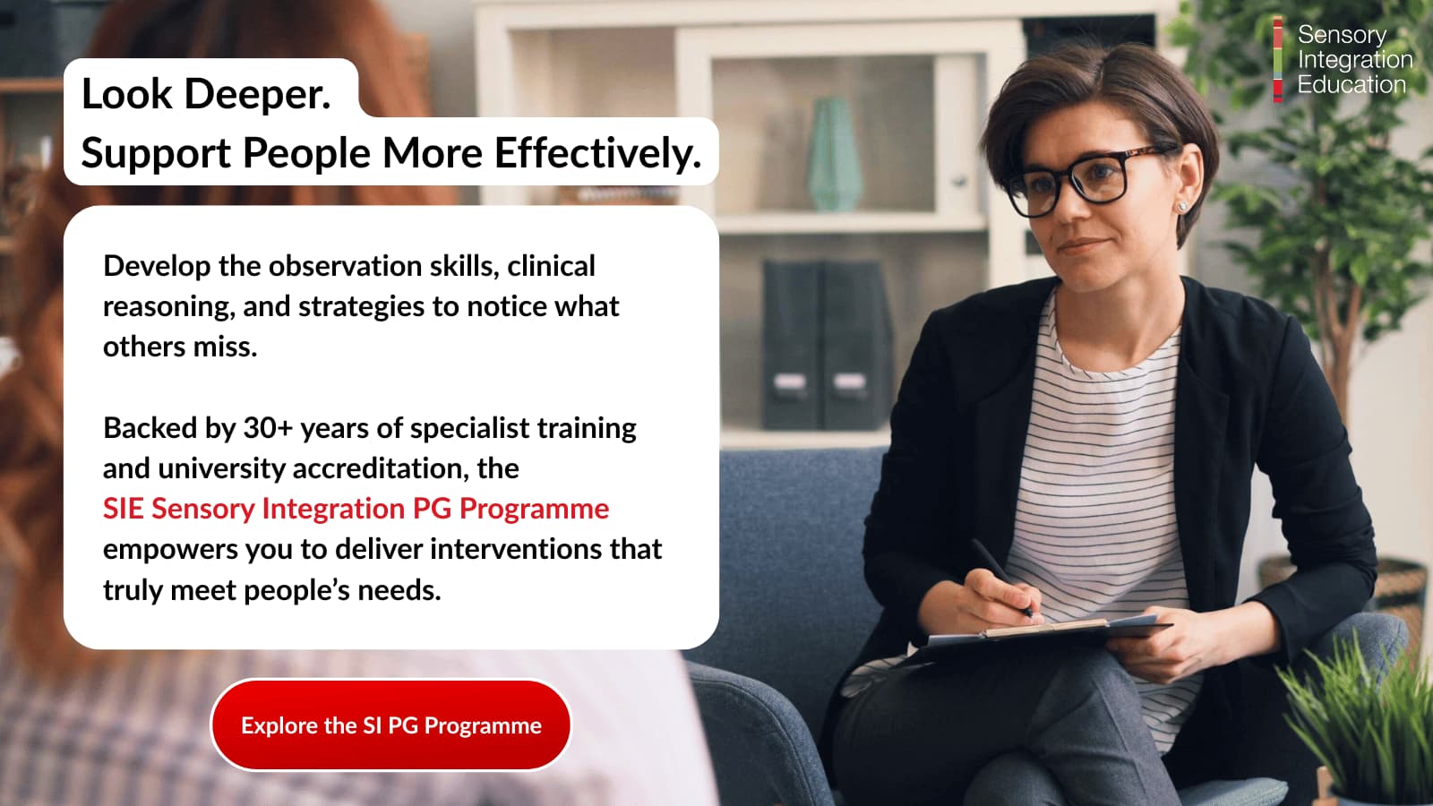 A professional sits holding her notes looking with empathy at the person she is supporting.