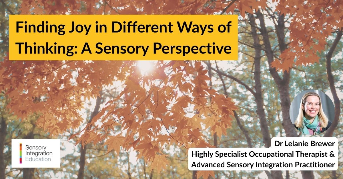 A woman wearing headphones is seated at a desk. She makes notes on a form whilst watching a laptop.