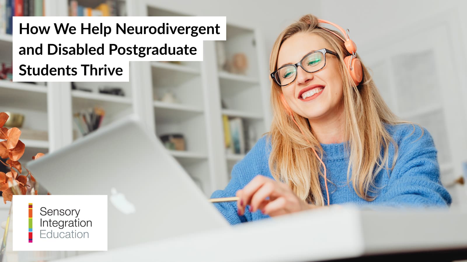 A woman in a blue jumper wearing peach headphones smiles as she looks at her laptop.