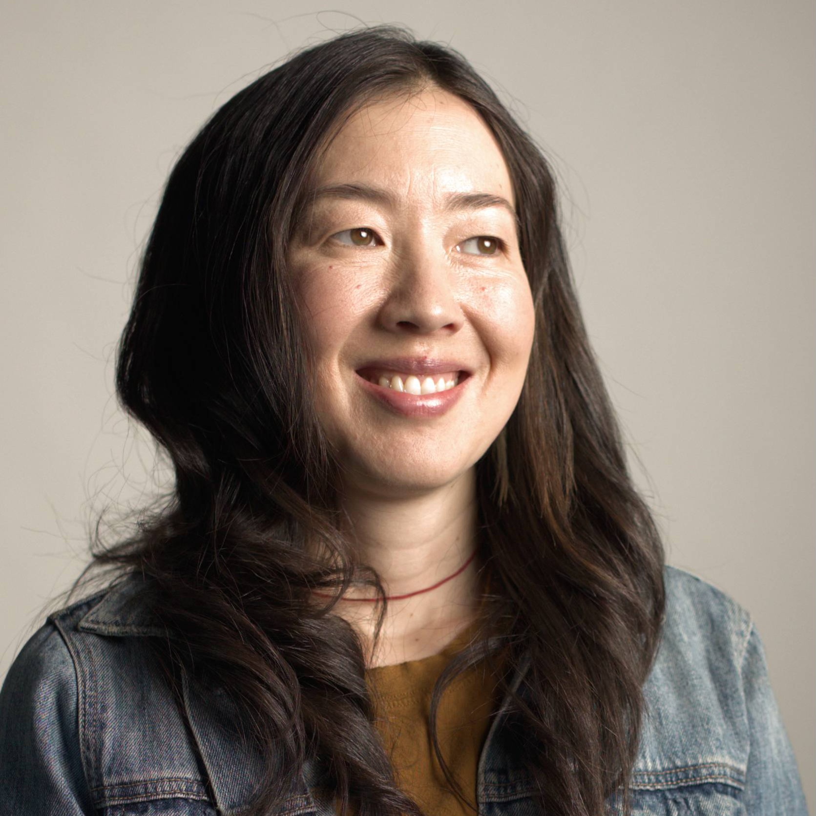 A portrait of teacher Cara Lai in front of a brown background.