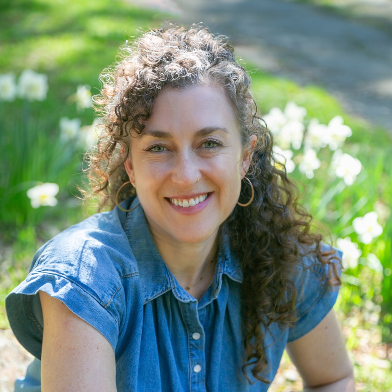 A portrait of teacher Devon Hase in front of a green background.