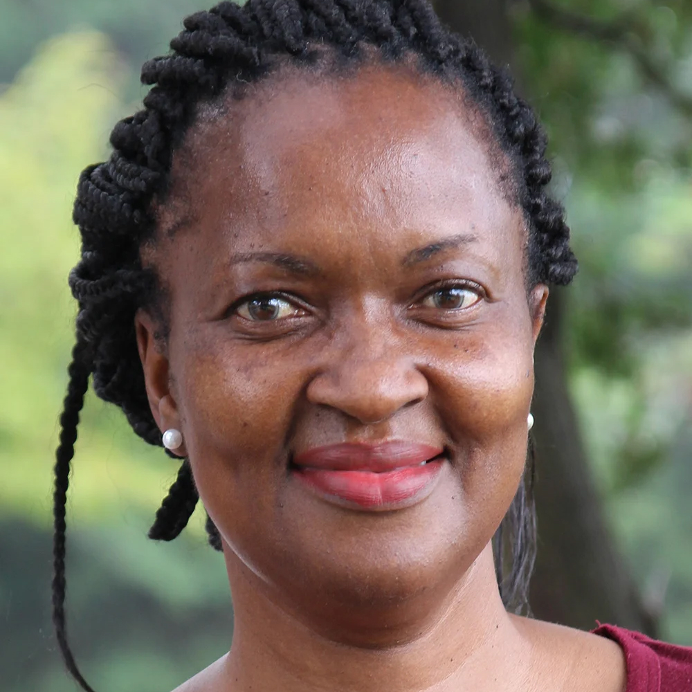 Portrait of teacher Nolitha Tsengiwe in front of a green background.