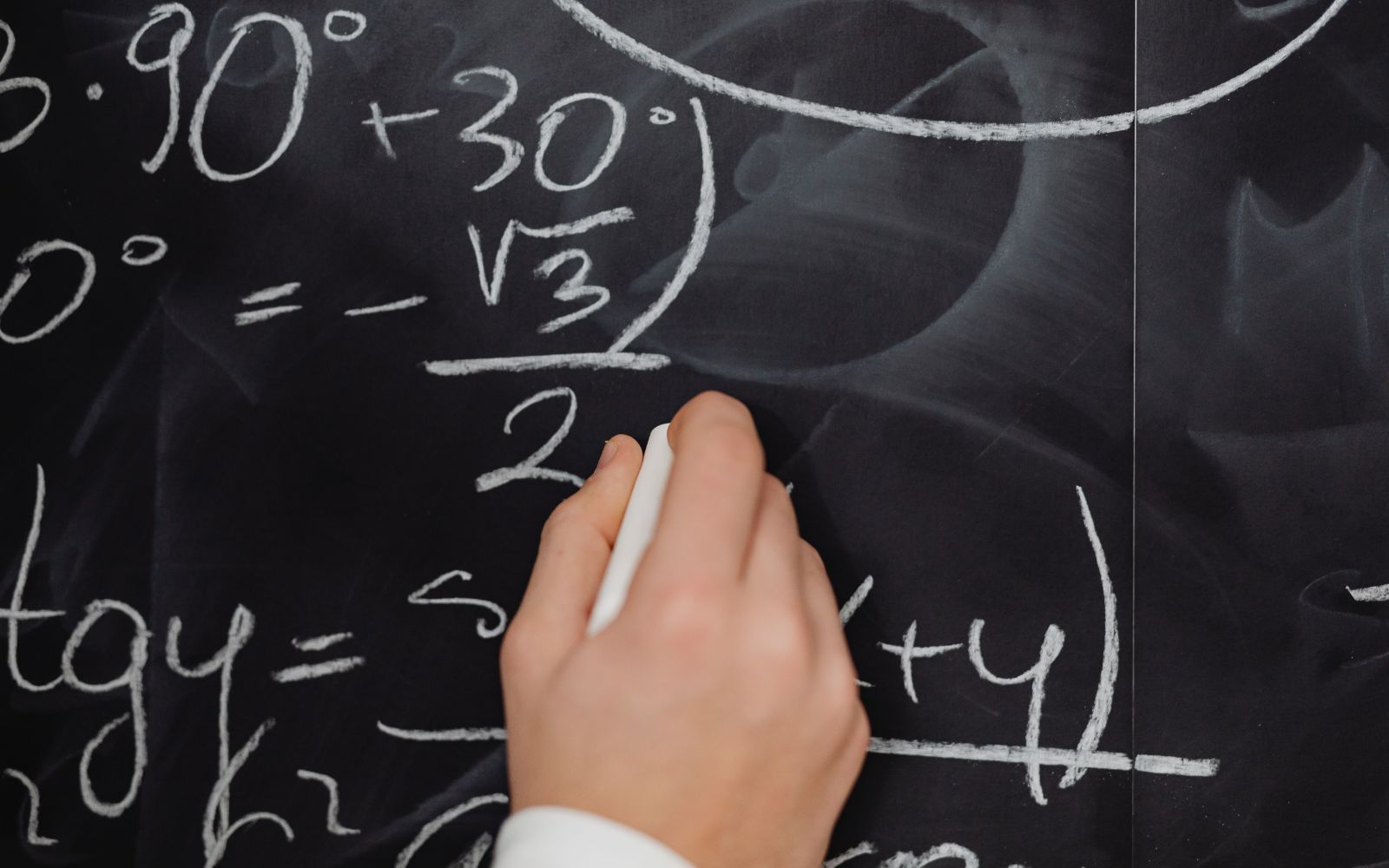 Student writing HKDSE maths formula on blackboard