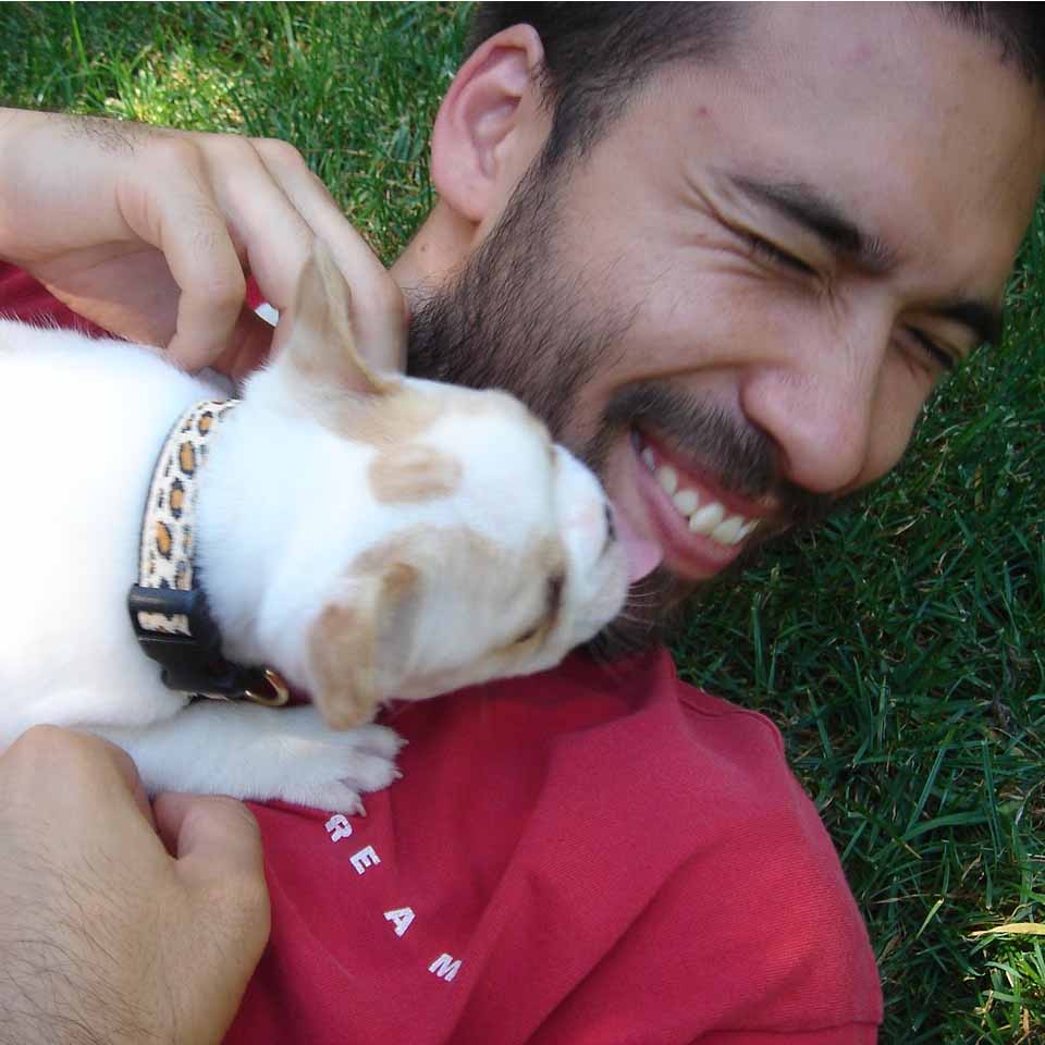 Jamie Dunbar laughing as a puppy licks his face