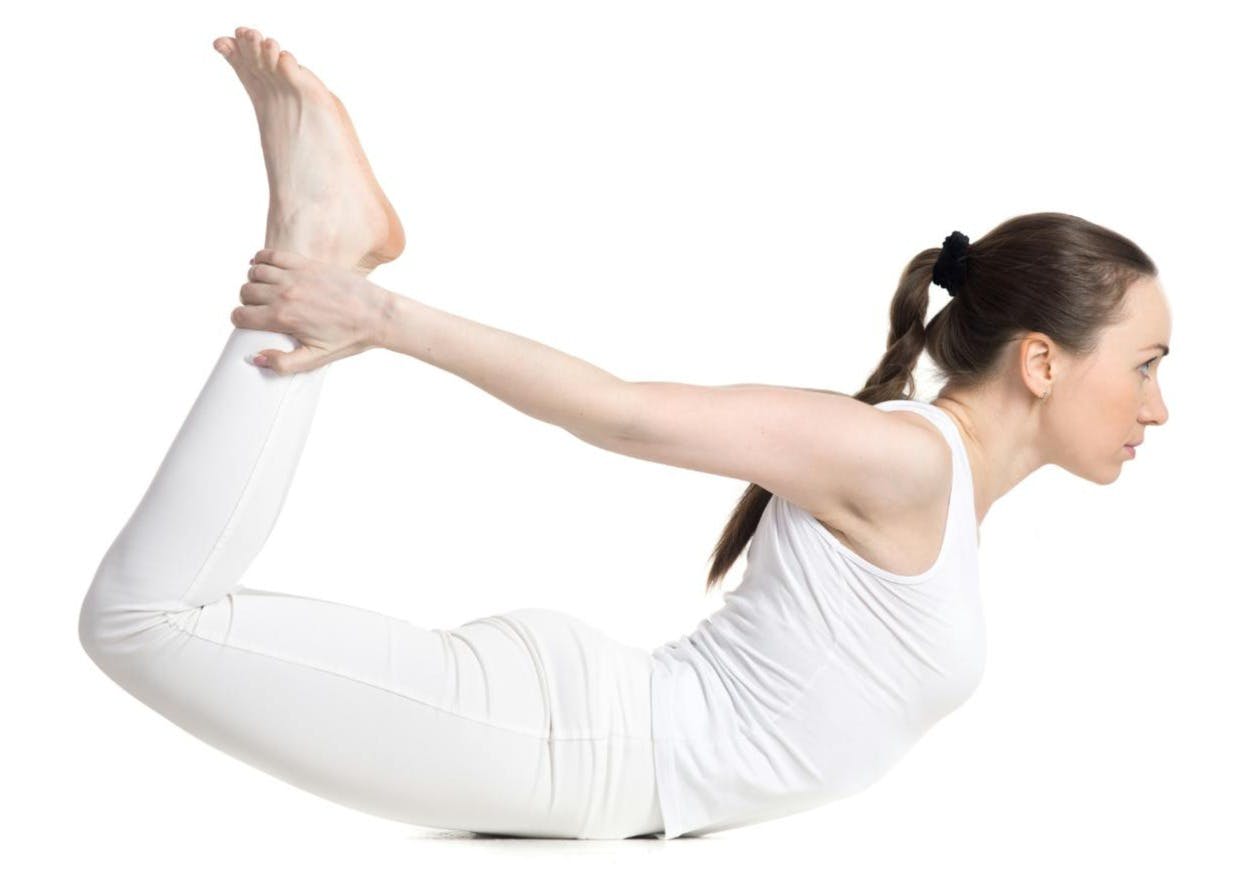 A person in white doing yogaDescription automatically generated