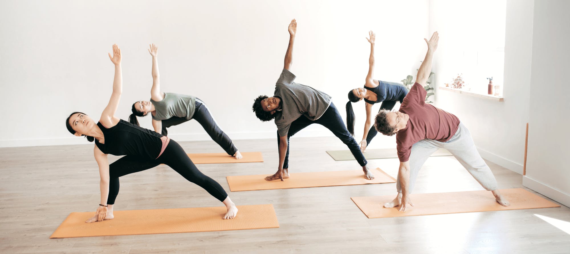 A group of people doing yogaDescription automatically generated