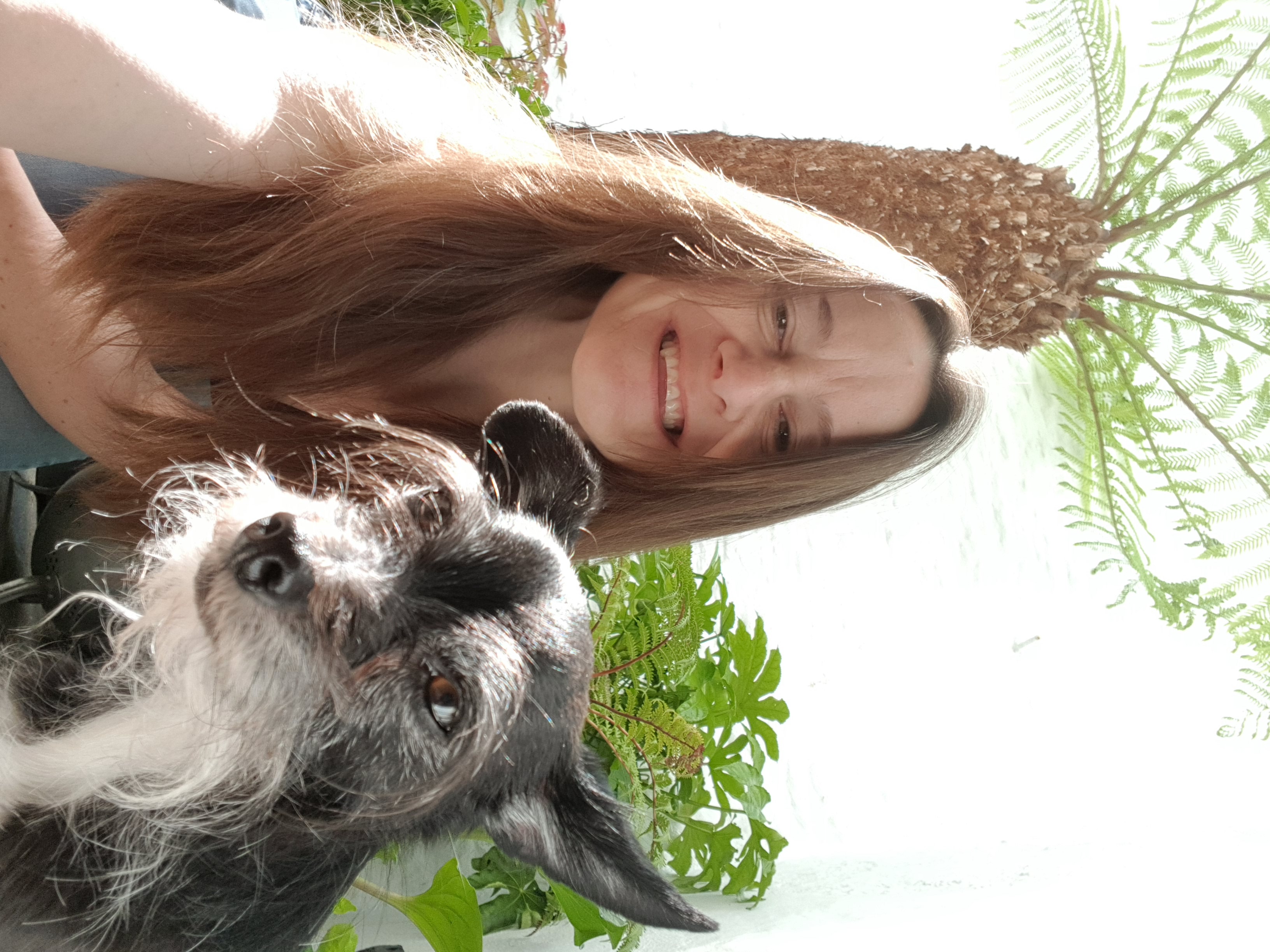 Dr Sara Davies MRCVS, veterinary behaviourist, with her small black and white mixed breed dog, Rita, in the backyard at her home in South Devon