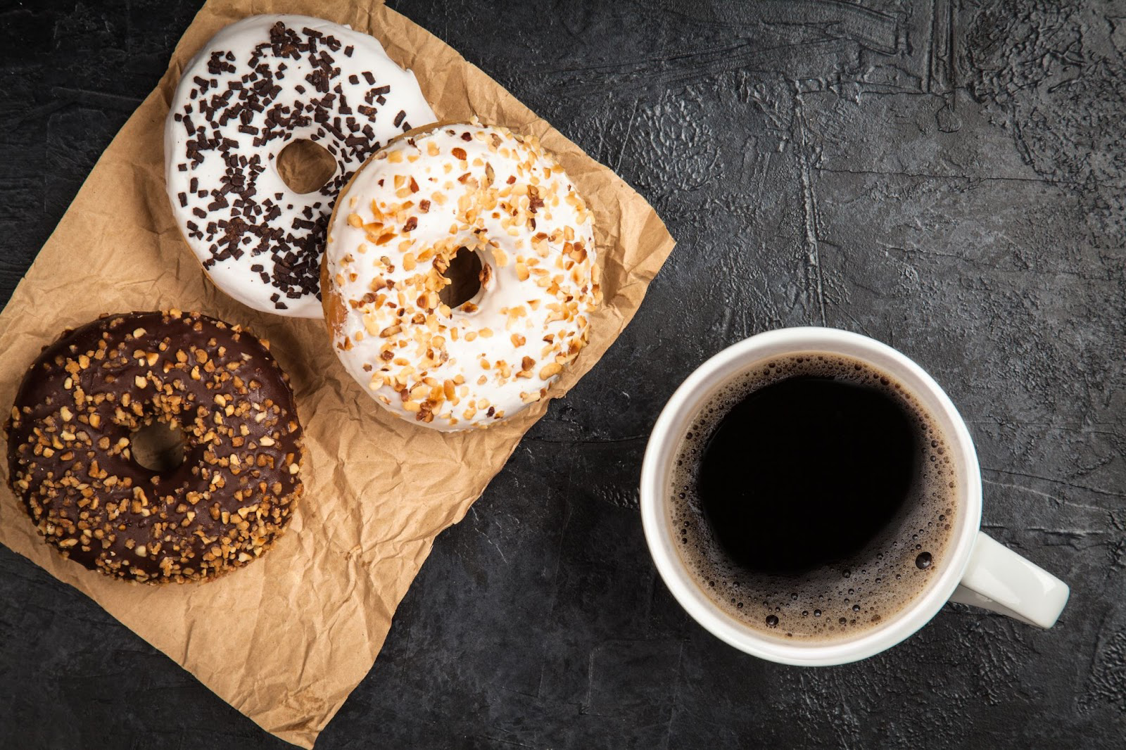 Three doughnuts and a cup of black coffee