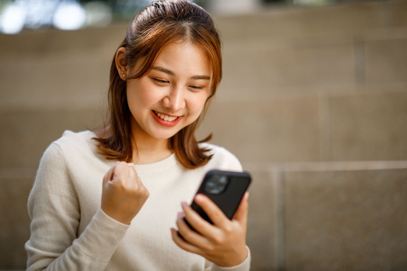 Woman excited looking at cell phone
