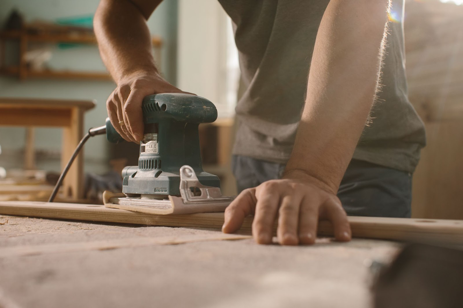 Man using a belt sander on a piece of wood