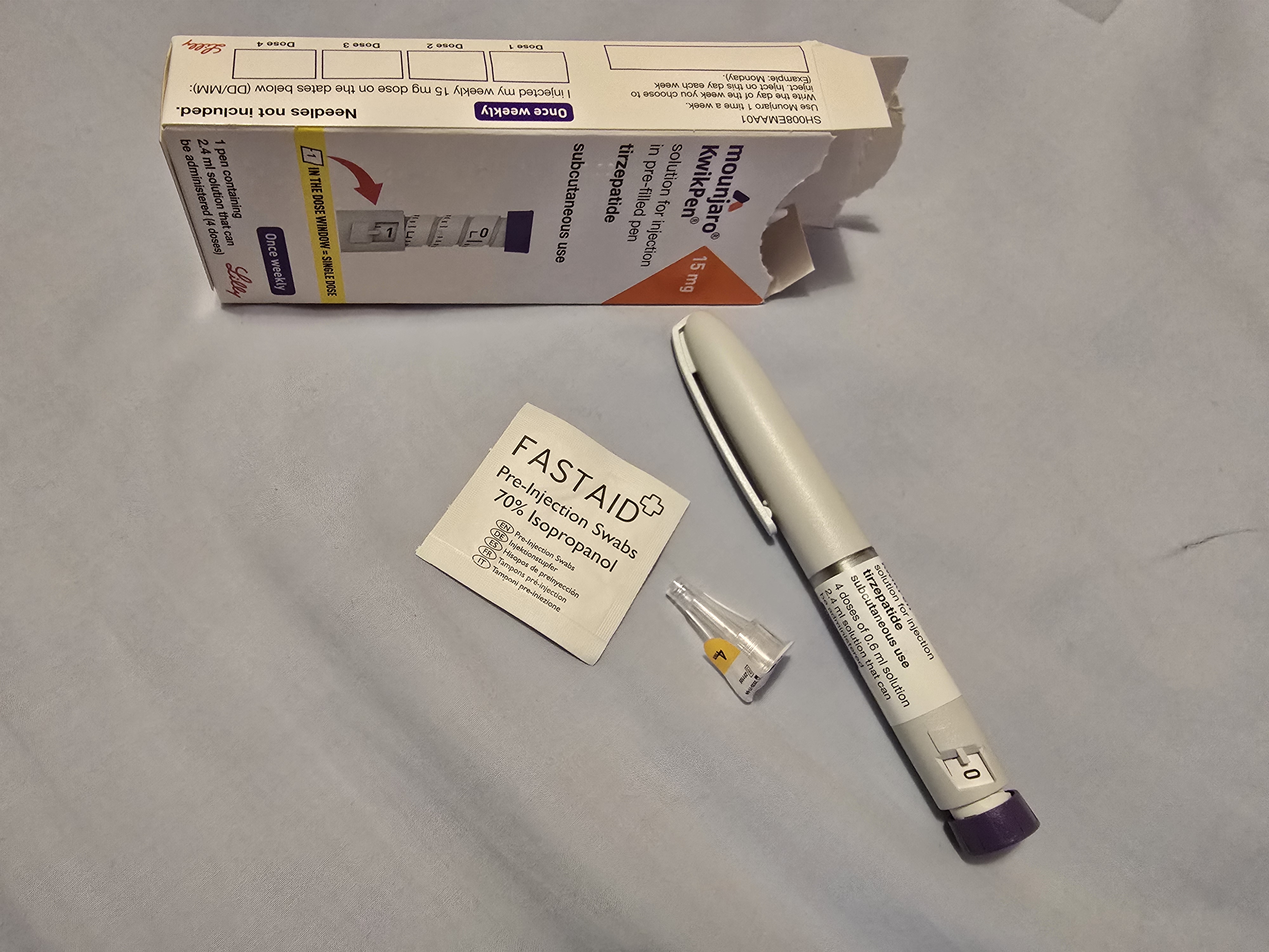 a mounjaro box and injection pen are placed with a medical wipe and new needle tip ready to use
