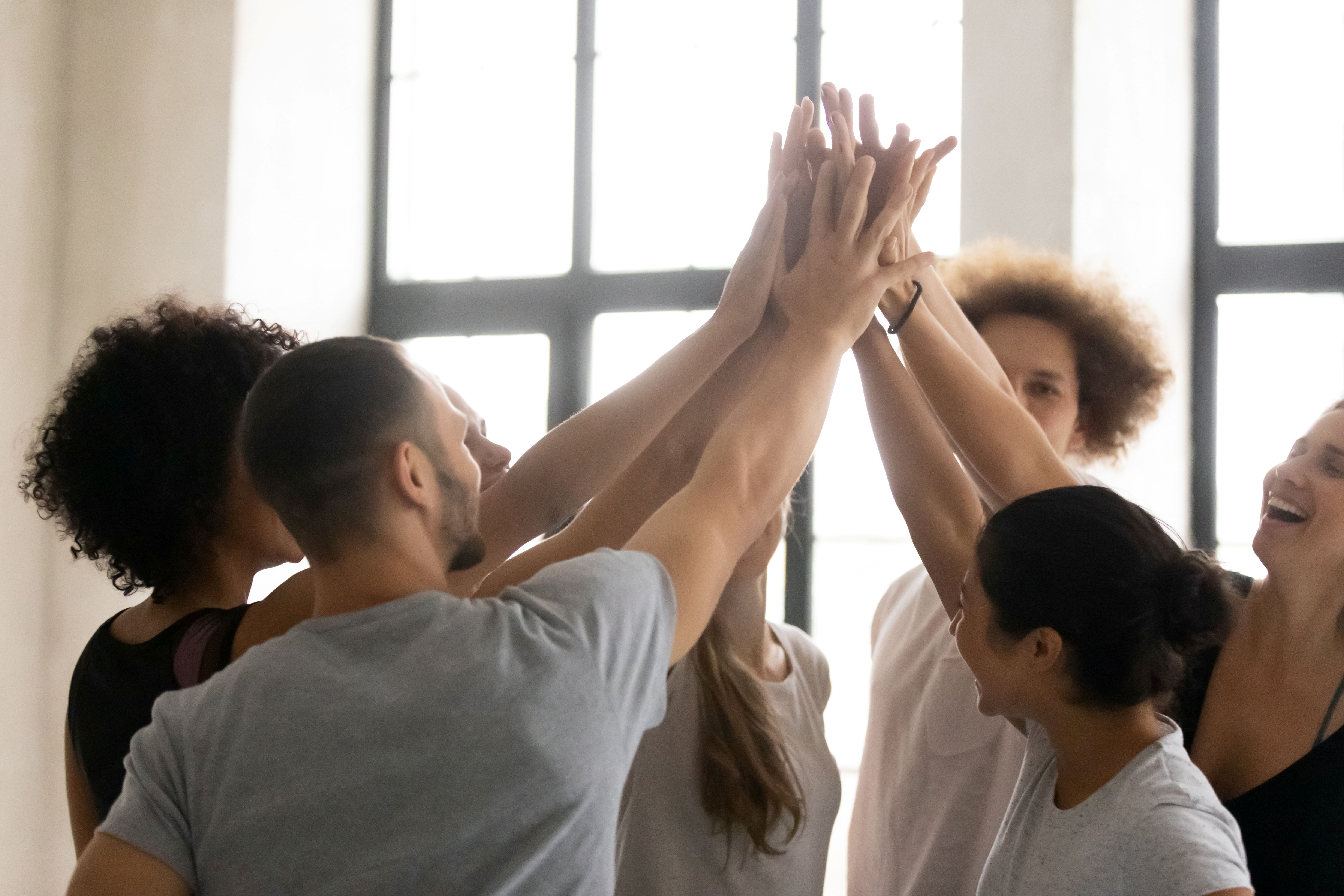 Multiethnic sporty people celebrating with a group high five