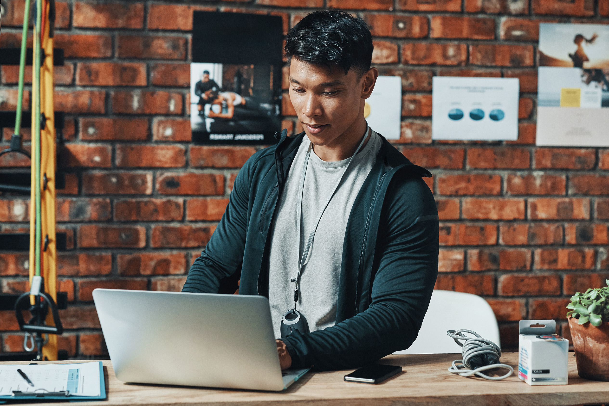 a man works on a laptop in a gym