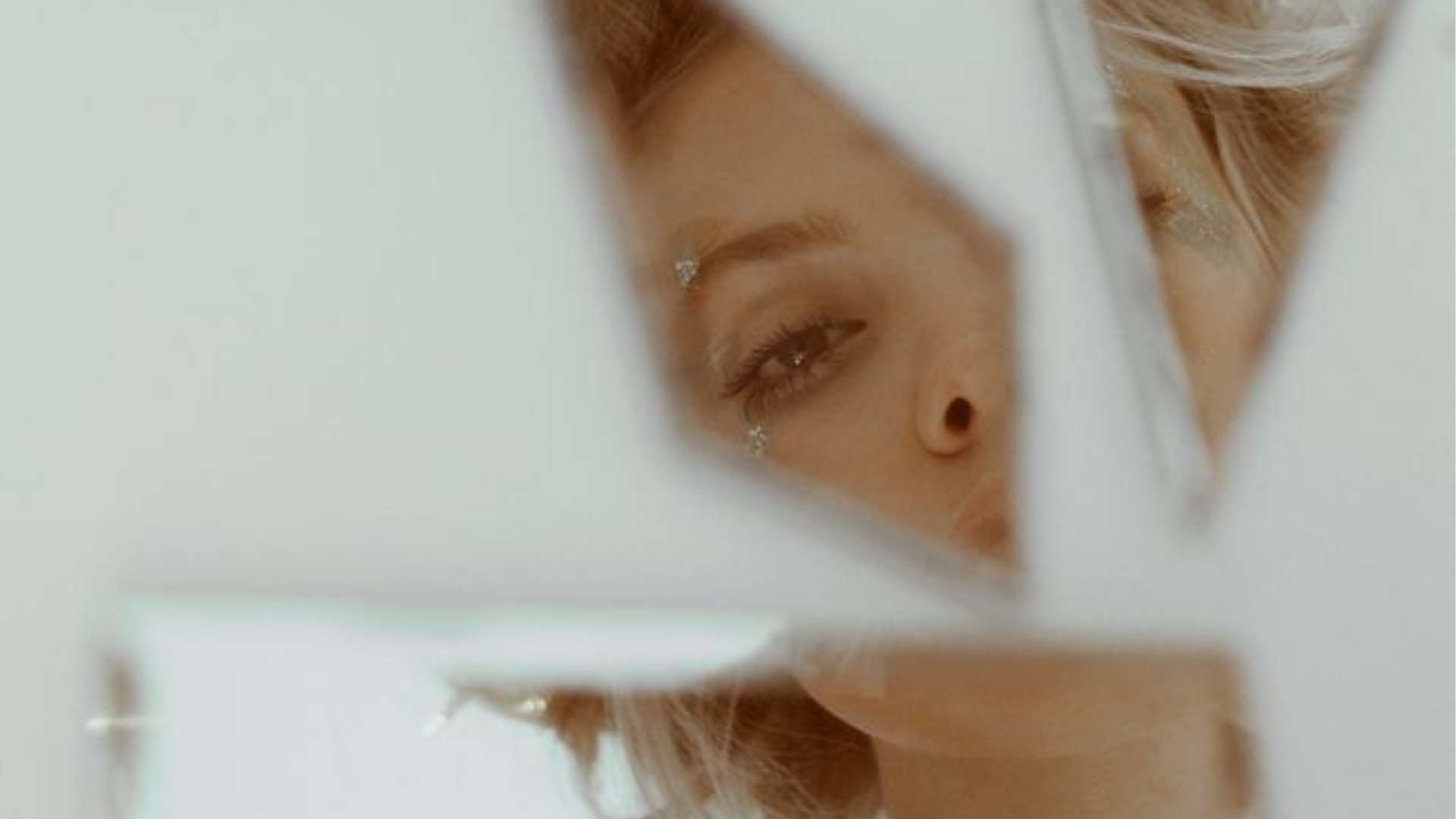 Törött üvegbe néz a szomorú nő