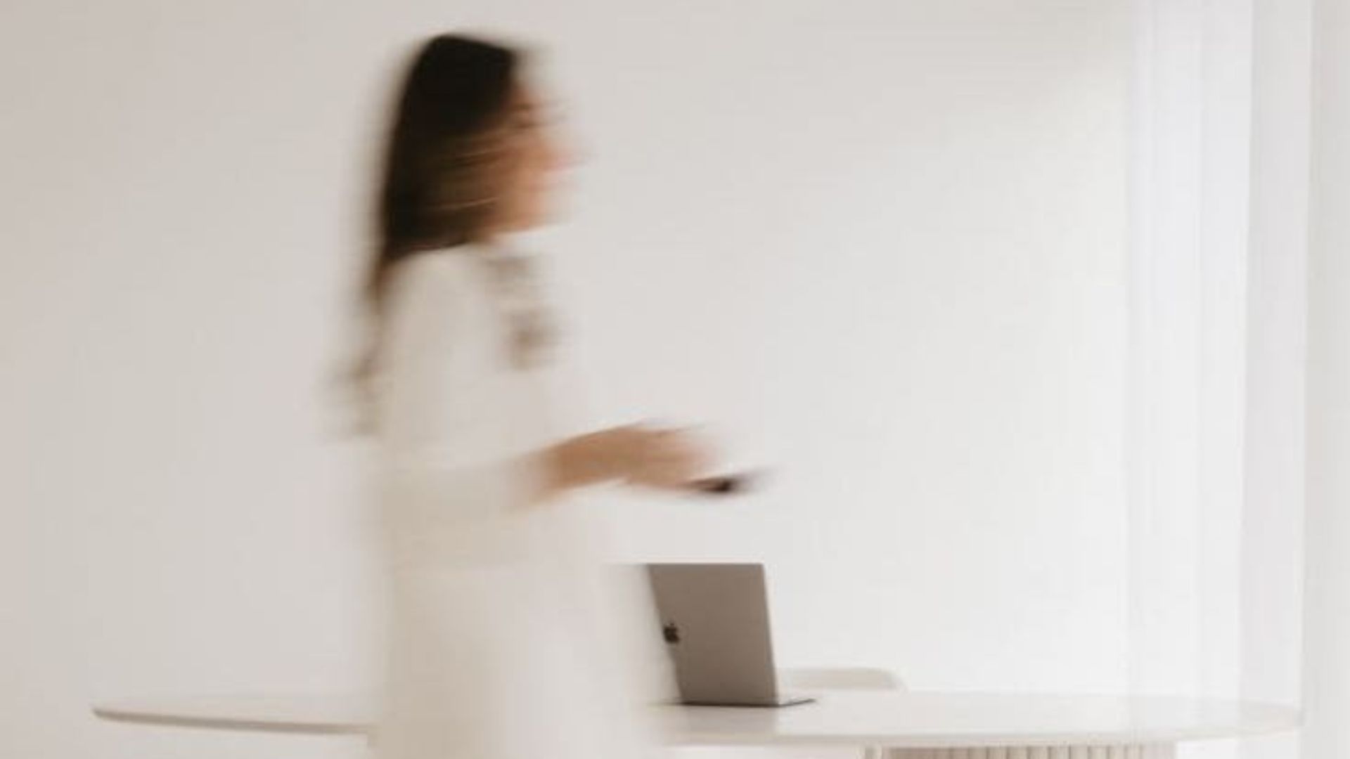elmosódó, rohanó, elfoglalt női alak az irodában