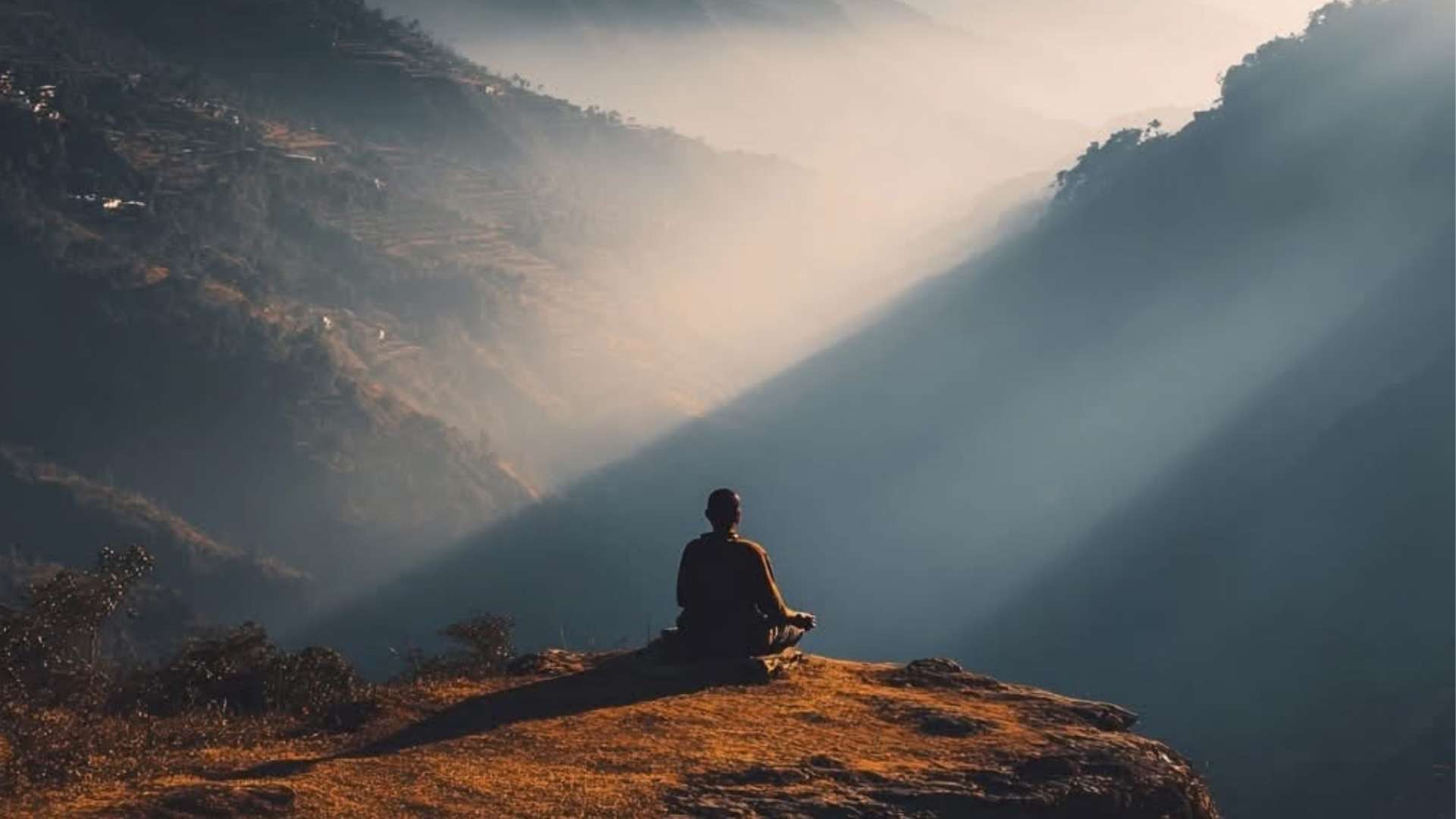 Hegyvidéki nyugodt környezetben meditáló férfi