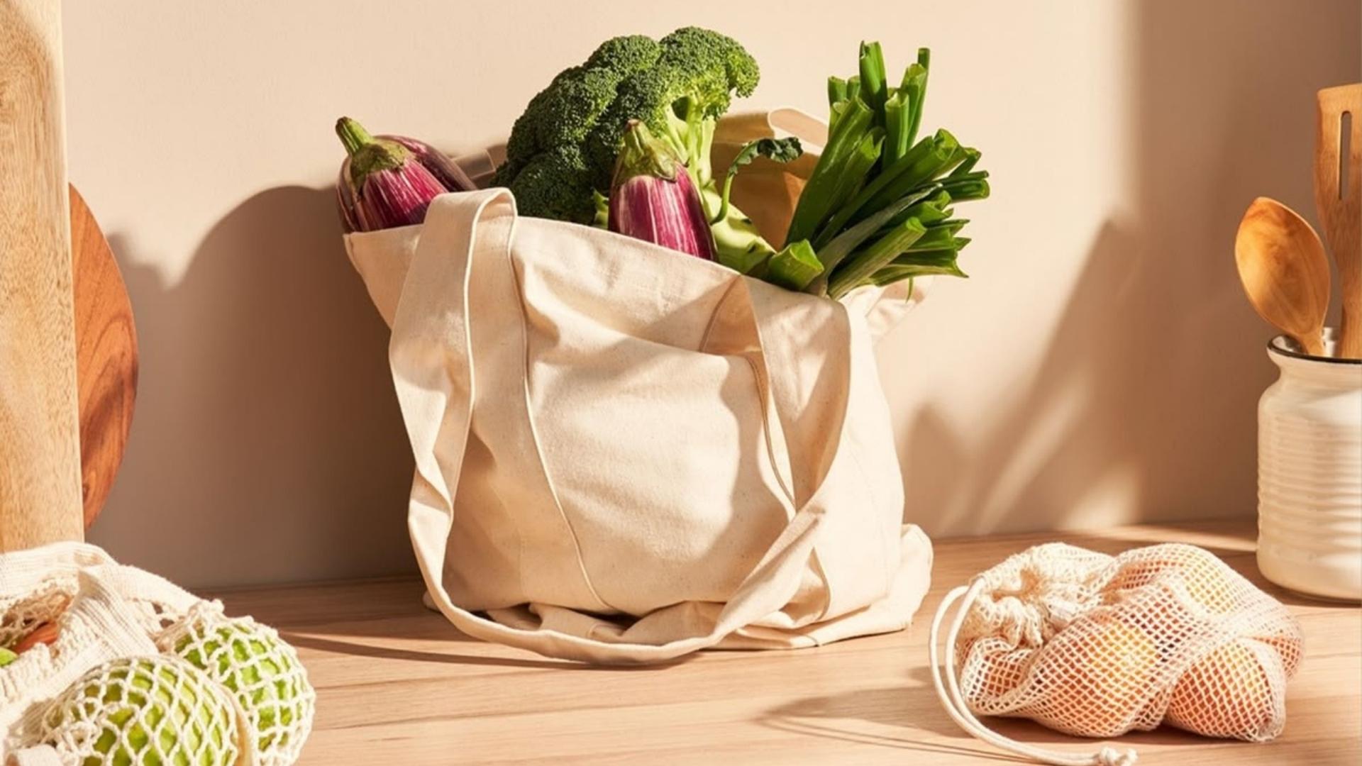 Zöldségek bevásárló zacskóban a konyhapulton