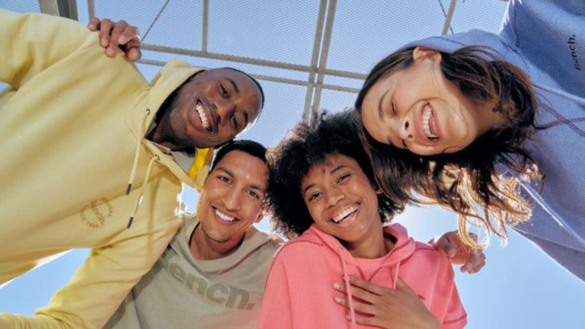 két fiatal lány és két fiatal fiú boldogan nevetnek színes pulcsiban